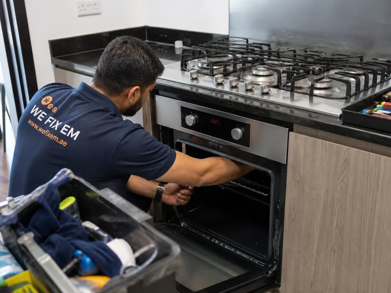 Oven repair technician in a Dubai kitchen